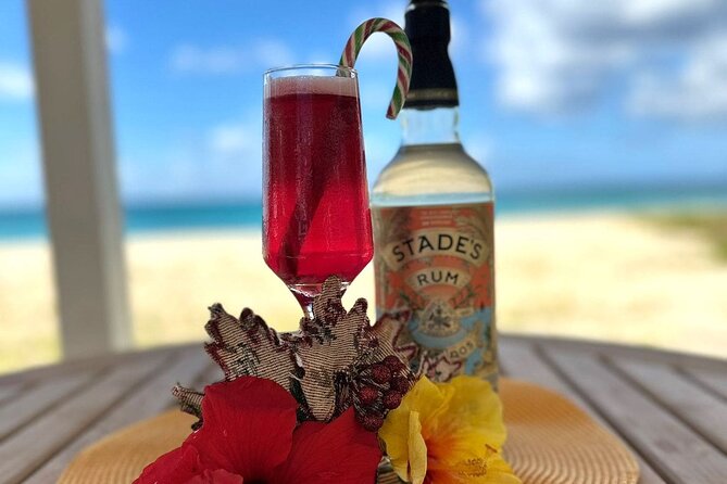 Rum cocktail and Stades Rum bottle in front of a tropical beach