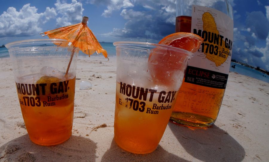 Mount Gay Rum bottle and glasses on the beach
